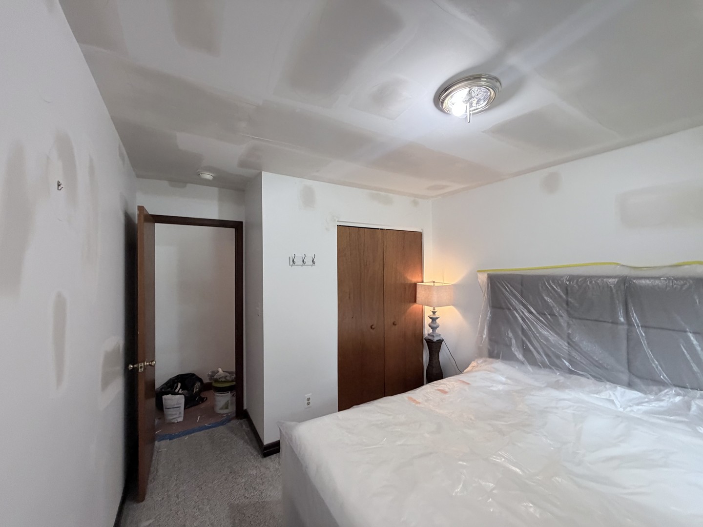 Ocean View bedroom during drywall repair preparation with surrounding furnishings protected