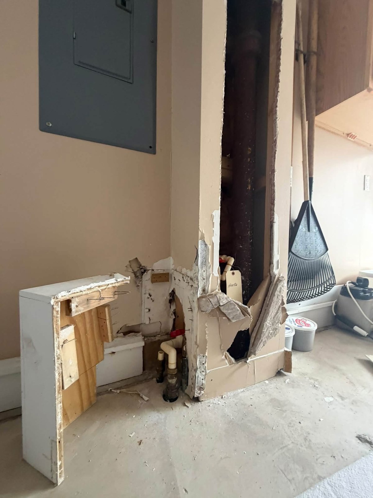 Close view of removed water-damaged drywall and opened plumbing access area in Rehoboth Beach